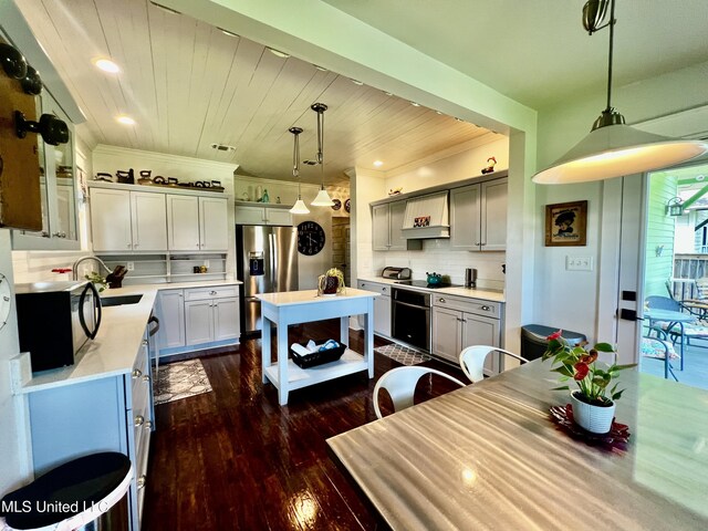 914 39th Ave, Gulfport, MS 39501 - kitchen featuring stainless steel refrigerator with ice dispenser, light countertops, dark wood-style flooring, backsplash, and a kitchen island with sink