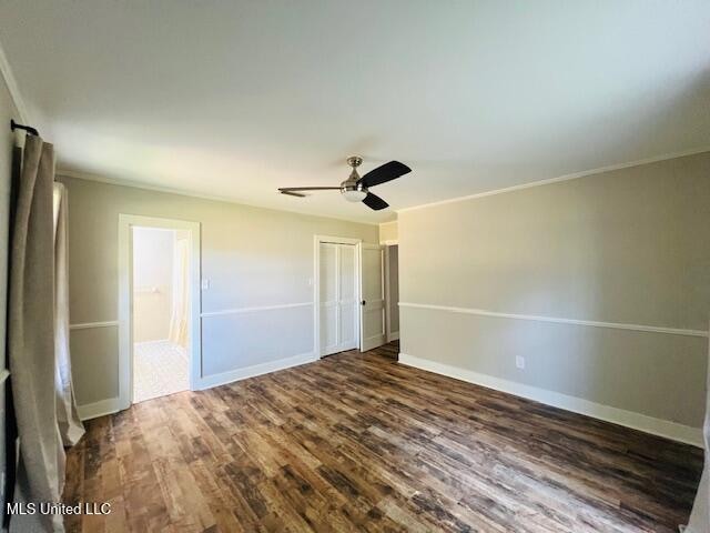 unfurnished bedroom featuring dark wood-type flooring, crown molding, and ceiling fan