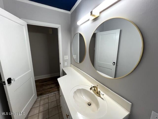 bathroom featuring vanity, ornamental molding, and tile patterned flooring