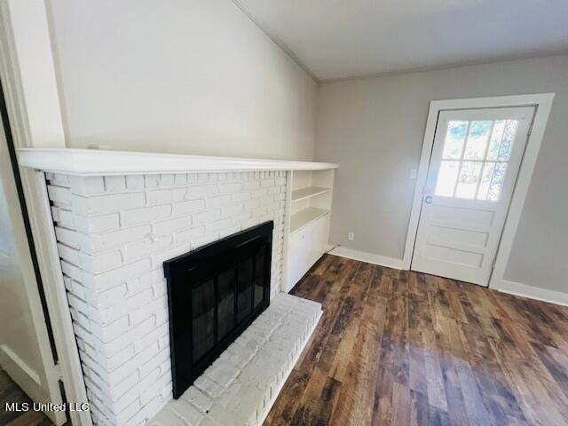 details with a brick fireplace and wood-type flooring