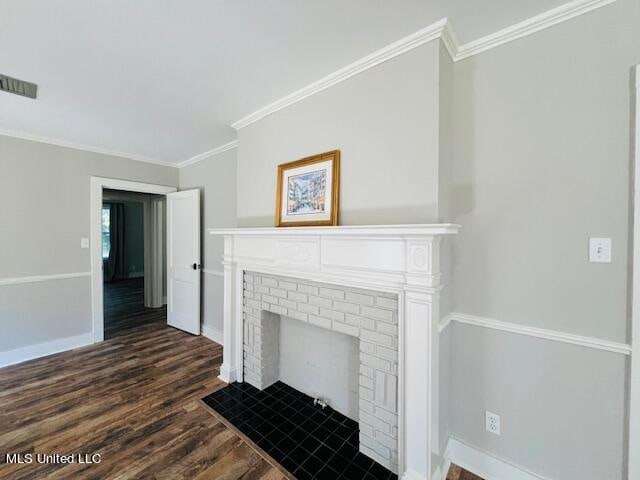 living room featuring dark wood-type flooring, crown molding, and a brick fireplace