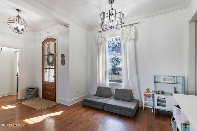 entrance foyer featuring ornamental molding, dark wood-type flooring, and an inviting chandelier