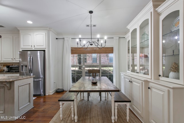 dining area featuring dark wood-type flooring and a notable chandelier