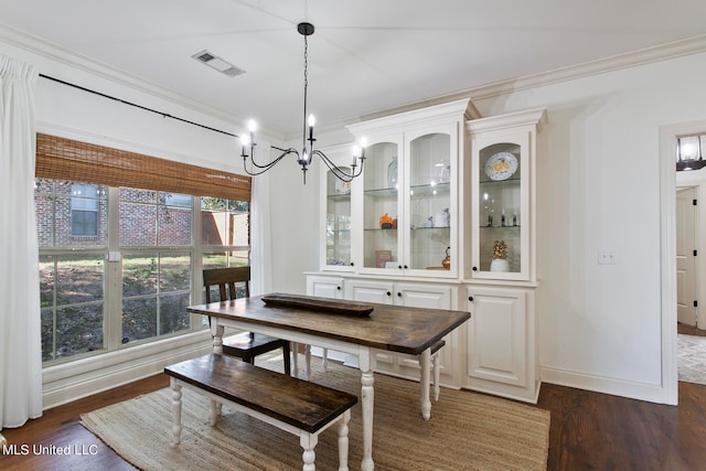 dining area with dark wood-type flooring and crown molding