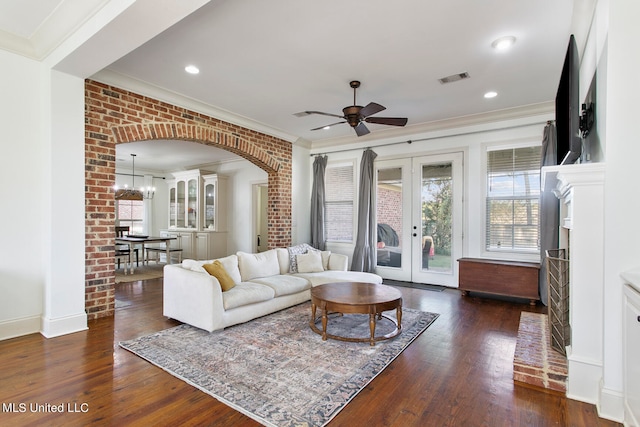 living room with crown molding, french doors, ceiling fan with notable chandelier, and dark hardwood / wood-style flooring