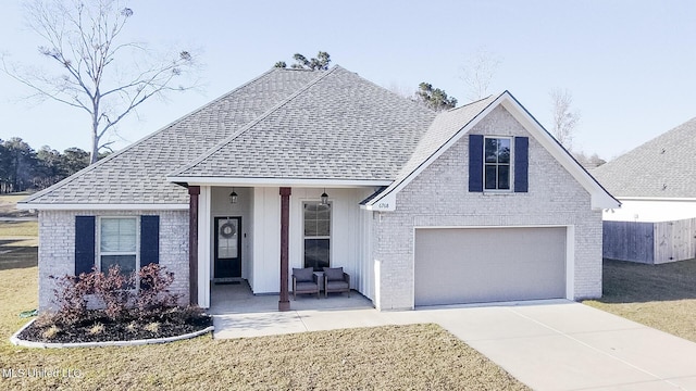 view of front facade with a front lawn, concrete driveway, and roof with shingles