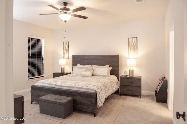 bedroom with light carpet, a ceiling fan, visible vents, and baseboards