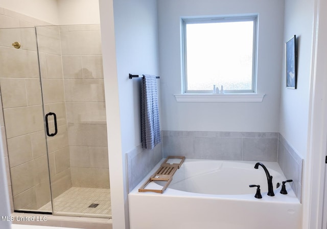 bathroom with a shower stall and a bath