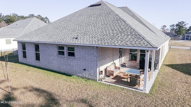 rear view of house featuring a yard, brick siding, and a patio