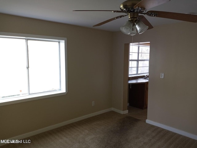 empty room featuring sink, carpet flooring, plenty of natural light, and ceiling fan