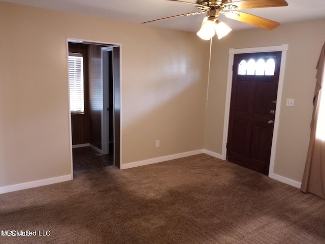 entryway with ceiling fan, plenty of natural light, and dark colored carpet