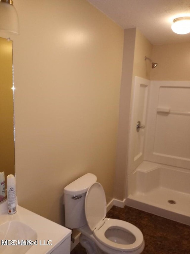 bathroom featuring vanity, toilet, walk in shower, and a textured ceiling