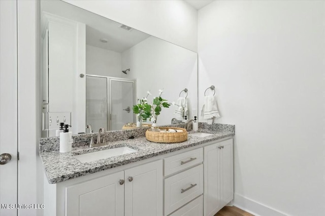 213 Dolly Ln, Magee, MS 39111 - bathroom featuring a shower stall, double vanity, wood finished floors, and baseboards