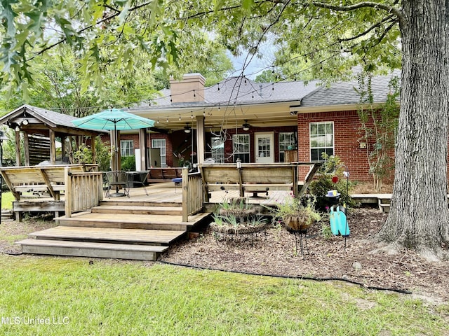 1024 Riverchase N Dr, Brandon, MS 39047 - back of property with ceiling fan, brick siding, roof with shingles, a wooden deck, and a chimney