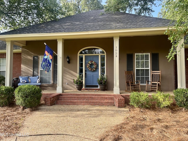 1024 Riverchase N Dr, Brandon, MS 39047 - doorway to property featuring roof with shingles, a porch, and stucco siding