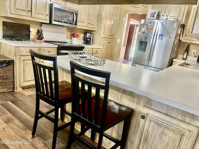 1024 Riverchase N Dr, Brandon, MS 39047 - kitchen featuring stainless steel appliances, light countertops, light wood-style floors, and a breakfast bar area