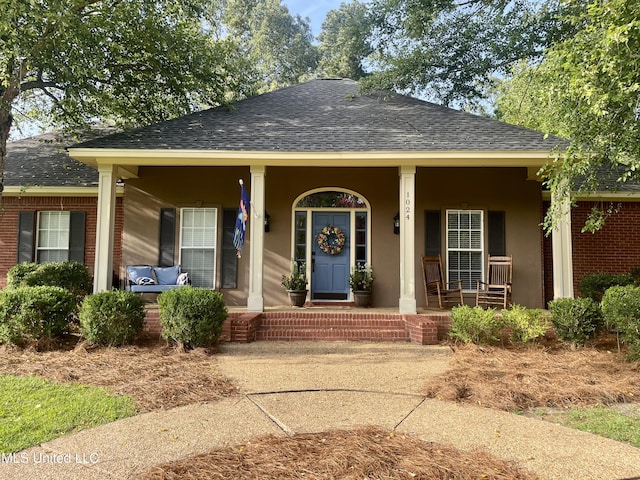 1024 Riverchase N Dr, Brandon, MS 39047 - view of front facade with roof with shingles, a porch, brick siding, and stucco siding