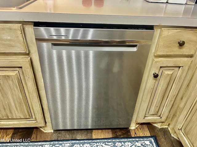1024 Riverchase N Dr, Brandon, MS 39047 - detailed view of stainless steel dishwasher, light brown cabinetry, and dark wood-type flooring