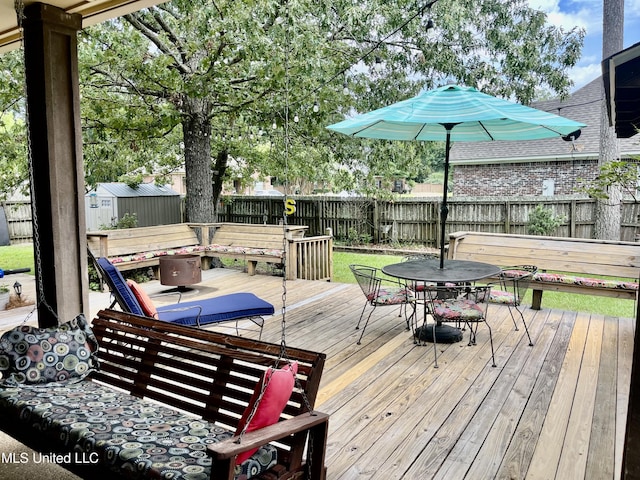 1024 Riverchase N Dr, Brandon, MS 39047 - deck with outdoor dining area, a fenced backyard, and a shed