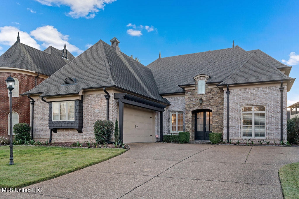 french country style house featuring a front lawn and a garage