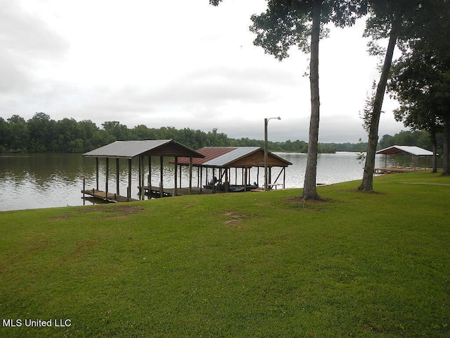 dock area with a lawn and a water view