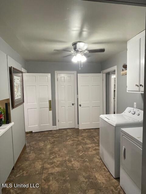 clothes washing area with ceiling fan, cabinet space, and washing machine and dryer
