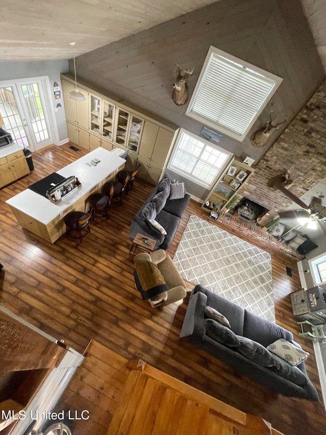 living room with ceiling fan, hardwood / wood-style flooring, and lofted ceiling