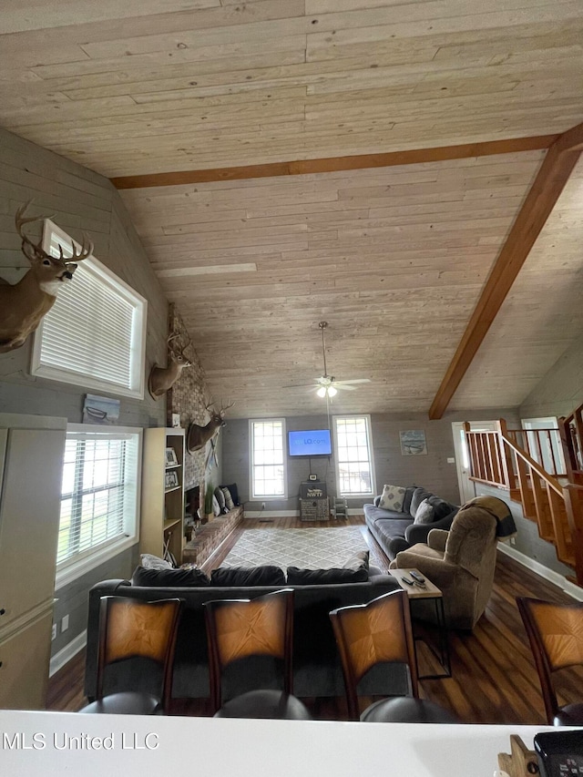 kitchen featuring wood ceiling, vaulted ceiling with beams, a kitchen breakfast bar, wood-type flooring, and ceiling fan