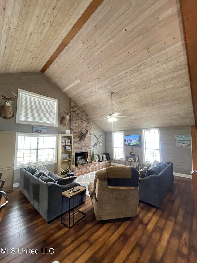 living room featuring a stone fireplace, vaulted ceiling with beams, dark hardwood / wood-style floors, wooden ceiling, and ceiling fan