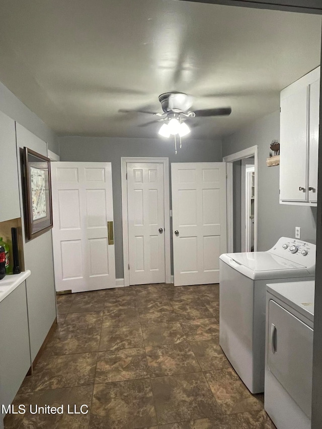 laundry area featuring ceiling fan, separate washer and dryer, and cabinets