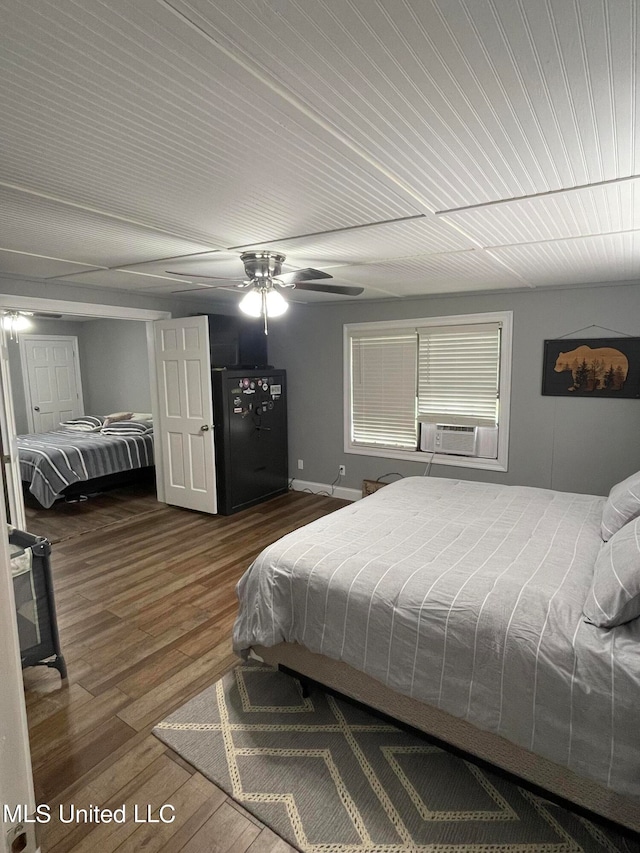 bedroom featuring hardwood / wood-style floors, cooling unit, and ceiling fan