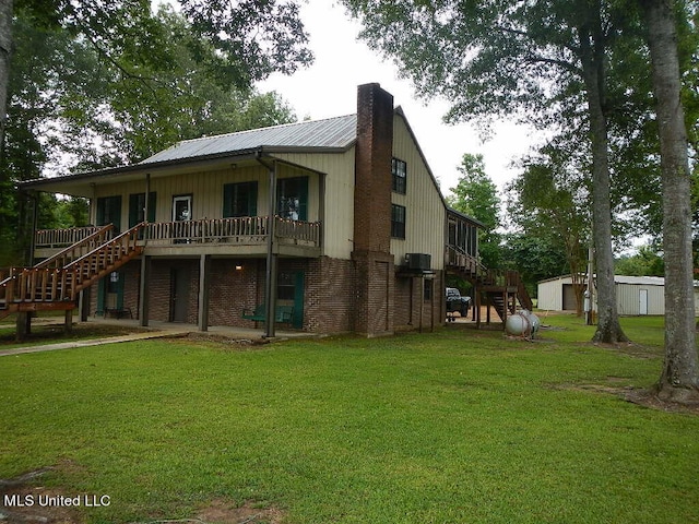 rear view of house with a wooden deck and a yard