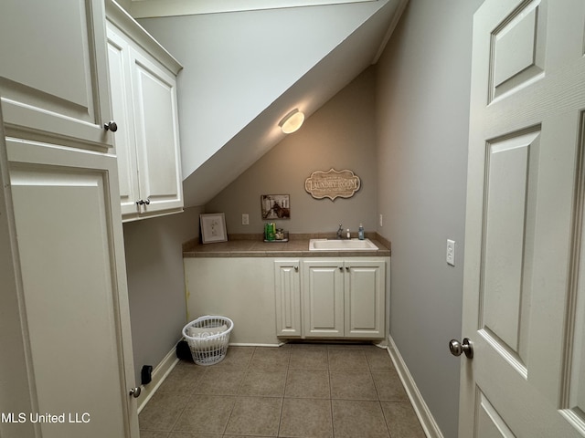 clothes washing area with sink and light tile patterned floors