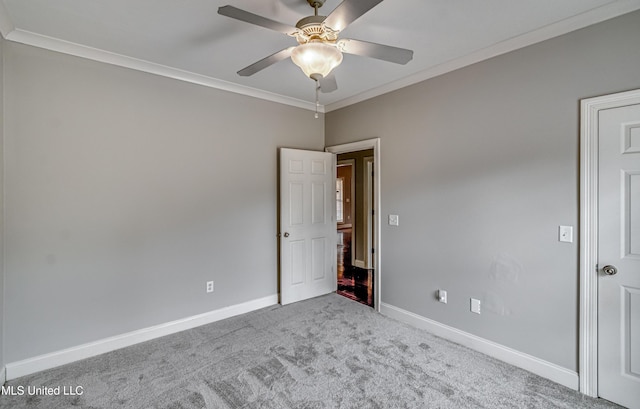 empty room with crown molding, light colored carpet, and ceiling fan