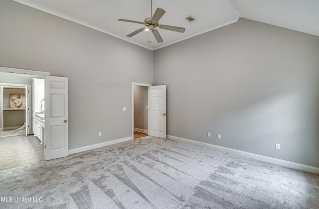 carpeted spare room featuring ceiling fan, ornamental molding, and high vaulted ceiling