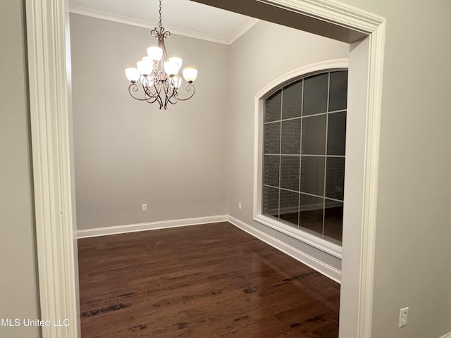 empty room with ornamental molding, dark hardwood / wood-style floors, and a chandelier