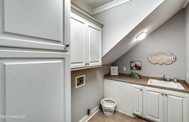 laundry area featuring light tile patterned flooring, cabinets, hookup for a washing machine, and sink