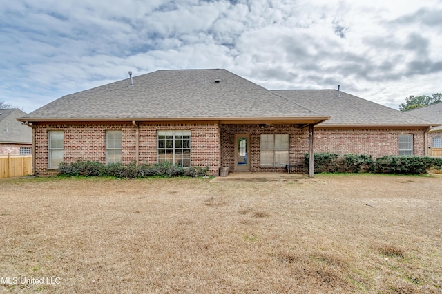 rear view of property featuring a lawn and a patio