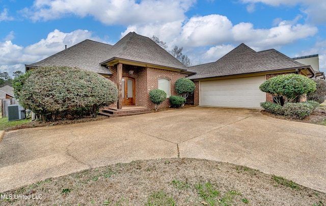 537 Turtle Ln, Brandon, MS 39047 - french country style house featuring brick siding, a shingled roof, concrete driveway, an attached garage, and central air condition unit