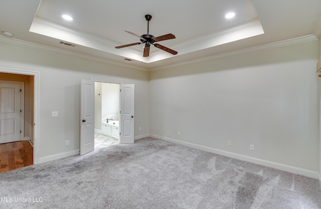 unfurnished bedroom featuring ceiling fan, a raised ceiling, and crown molding