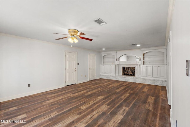 unfurnished living room featuring ornamental molding, dark wood-type flooring, a brick fireplace, and ceiling fan