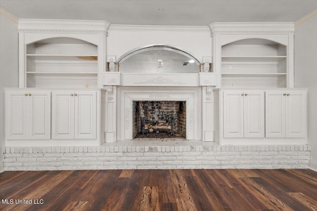 unfurnished living room featuring ornamental molding, dark hardwood / wood-style flooring, and a brick fireplace