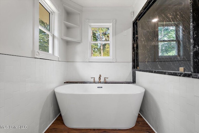 bathroom featuring hardwood / wood-style floors, a healthy amount of sunlight, and a bathing tub