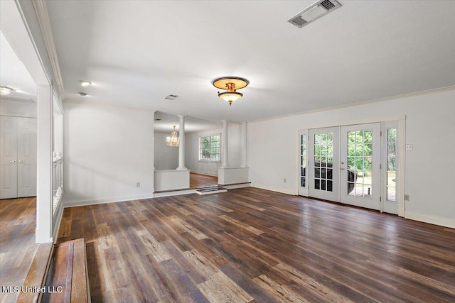 unfurnished living room with french doors, ornate columns, dark wood-type flooring, and a wealth of natural light