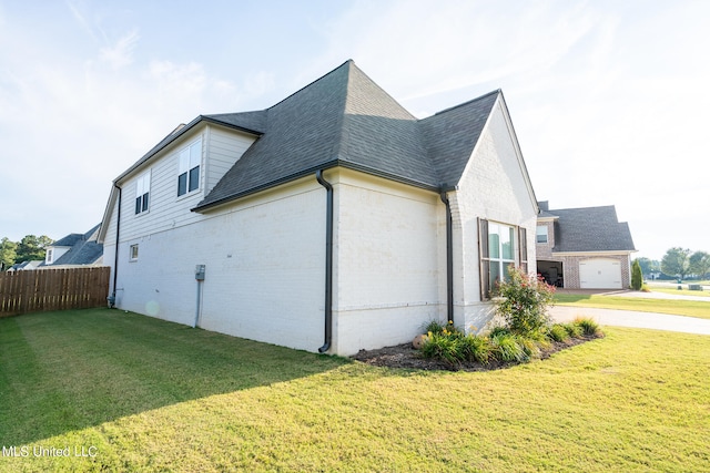 view of side of property with a garage and a lawn