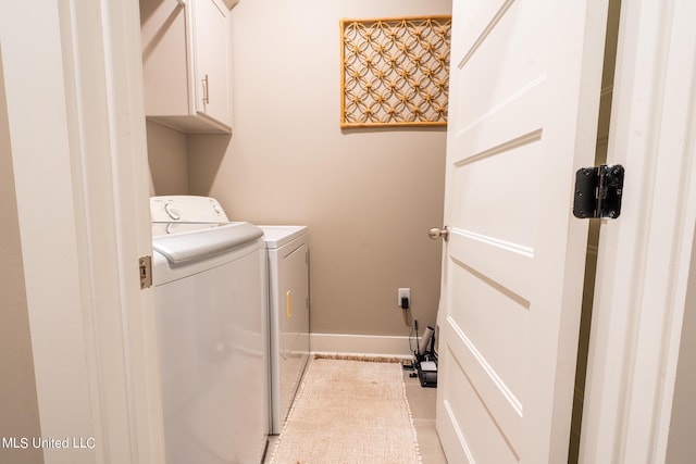 washroom with washer and clothes dryer, light tile patterned floors, and cabinets