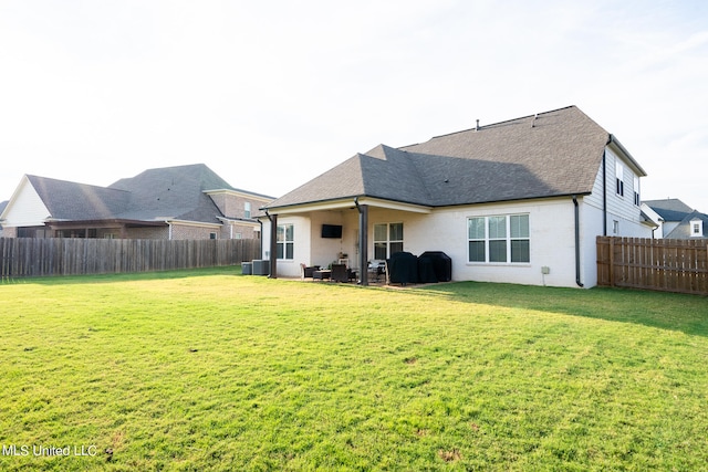 rear view of house with a yard, a patio area, and central AC