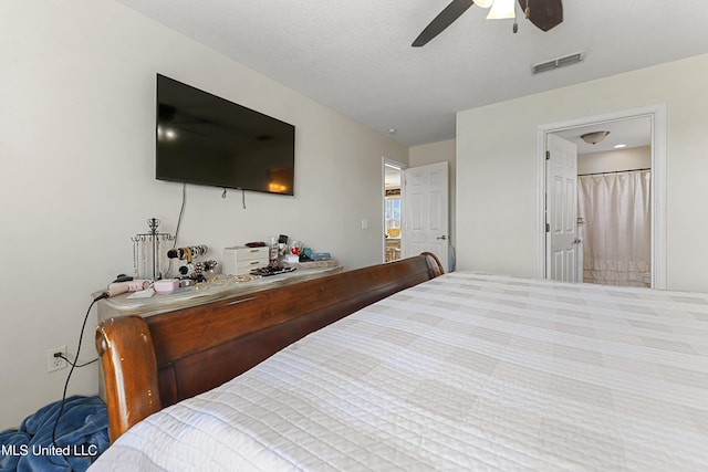 bedroom featuring a textured ceiling, visible vents, and ceiling fan