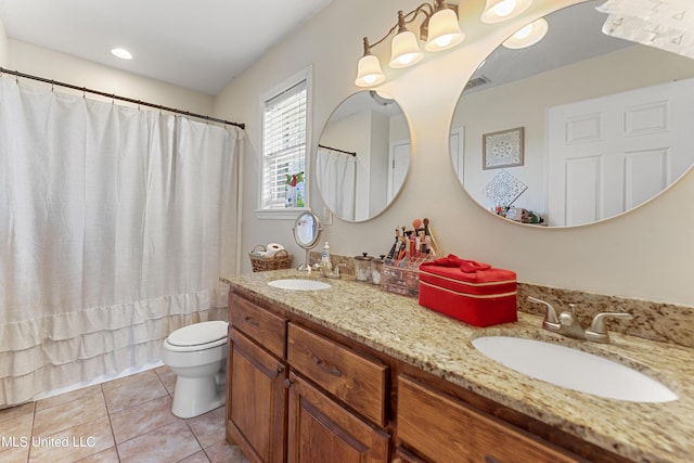 bathroom with tile patterned flooring, double vanity, toilet, and a sink