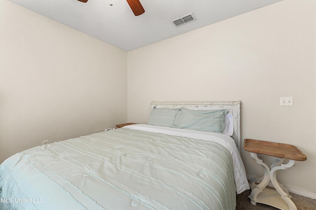 carpeted bedroom with visible vents, baseboards, and a ceiling fan